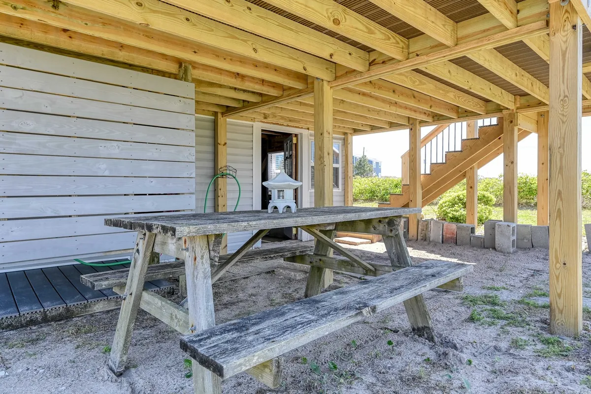 An outdoor area featuring a picnic table, staircase, and lantern, set up for family gatherings and outdoor dining. The area looks inviting, ideal for meals after a day of exploration and nature activities.